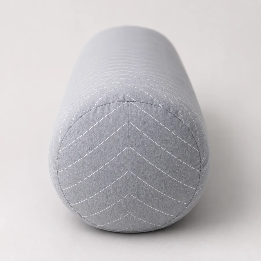 Coussin de grossesse vu de bout, l'epaisseur du boudin lisible contre un fond neutre