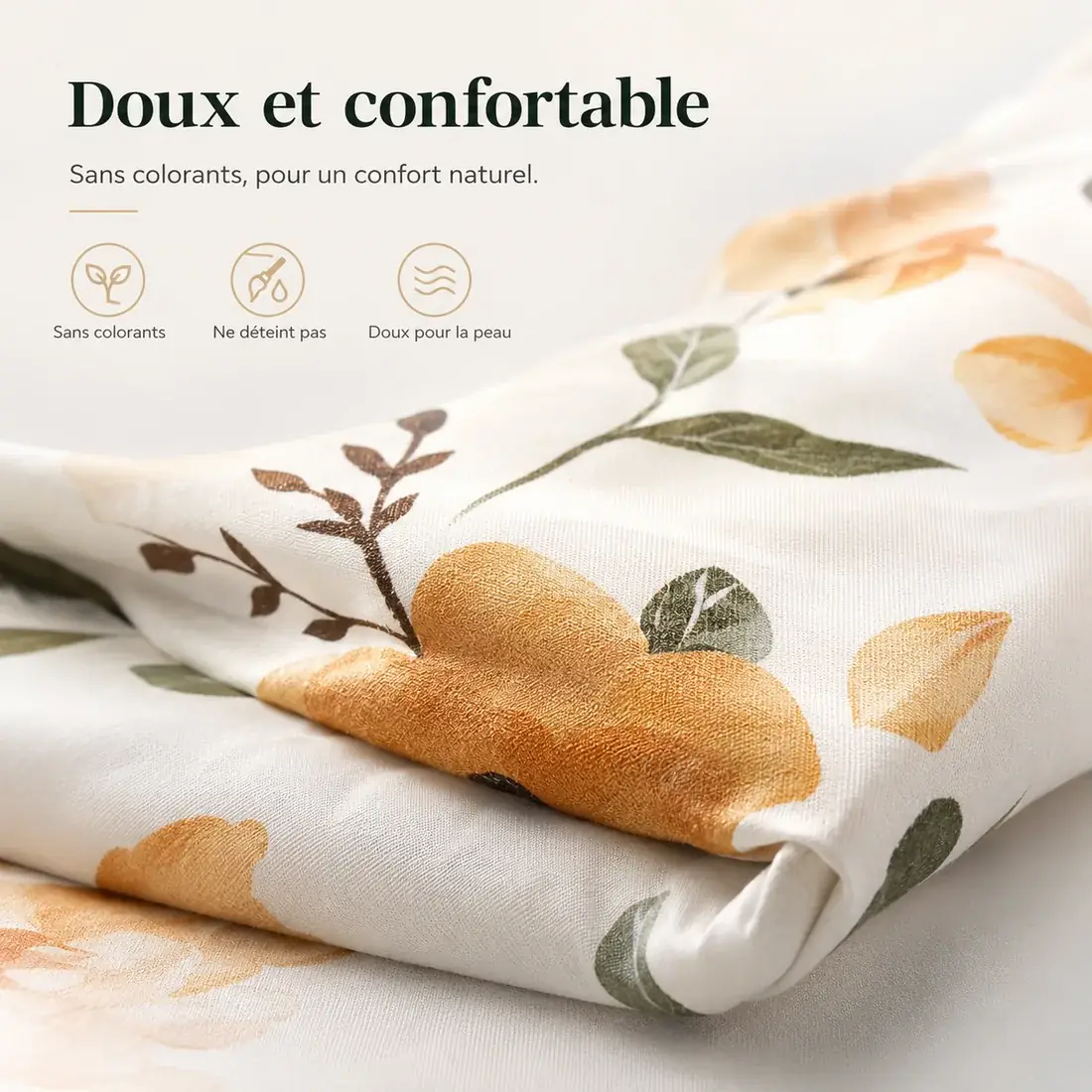 Gros plan sur le tissu du coussin d’allaitement, motif floral aux tons ocre et vert, plié sur lui-même