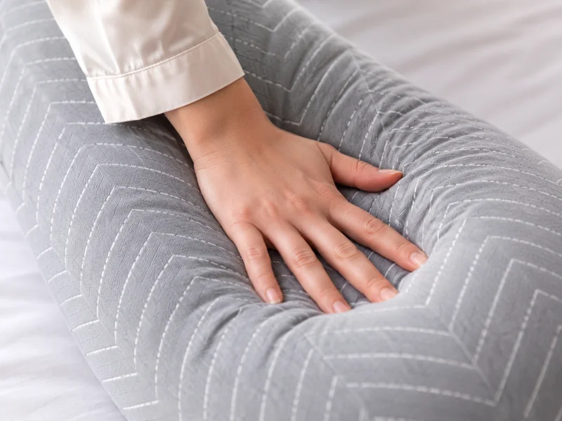 Main appuyant à plat sur la branche du coussin pour en juger la fermeté