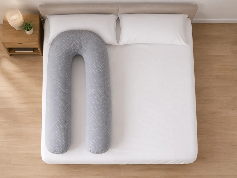 Lit double vu du dessus, le coussin en U occupant un côté du matelas